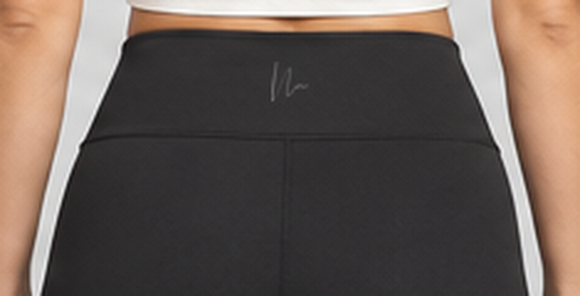 Close-up of the exact Double N monogram at the back waistband of the black Luxe Crossover Leggings.